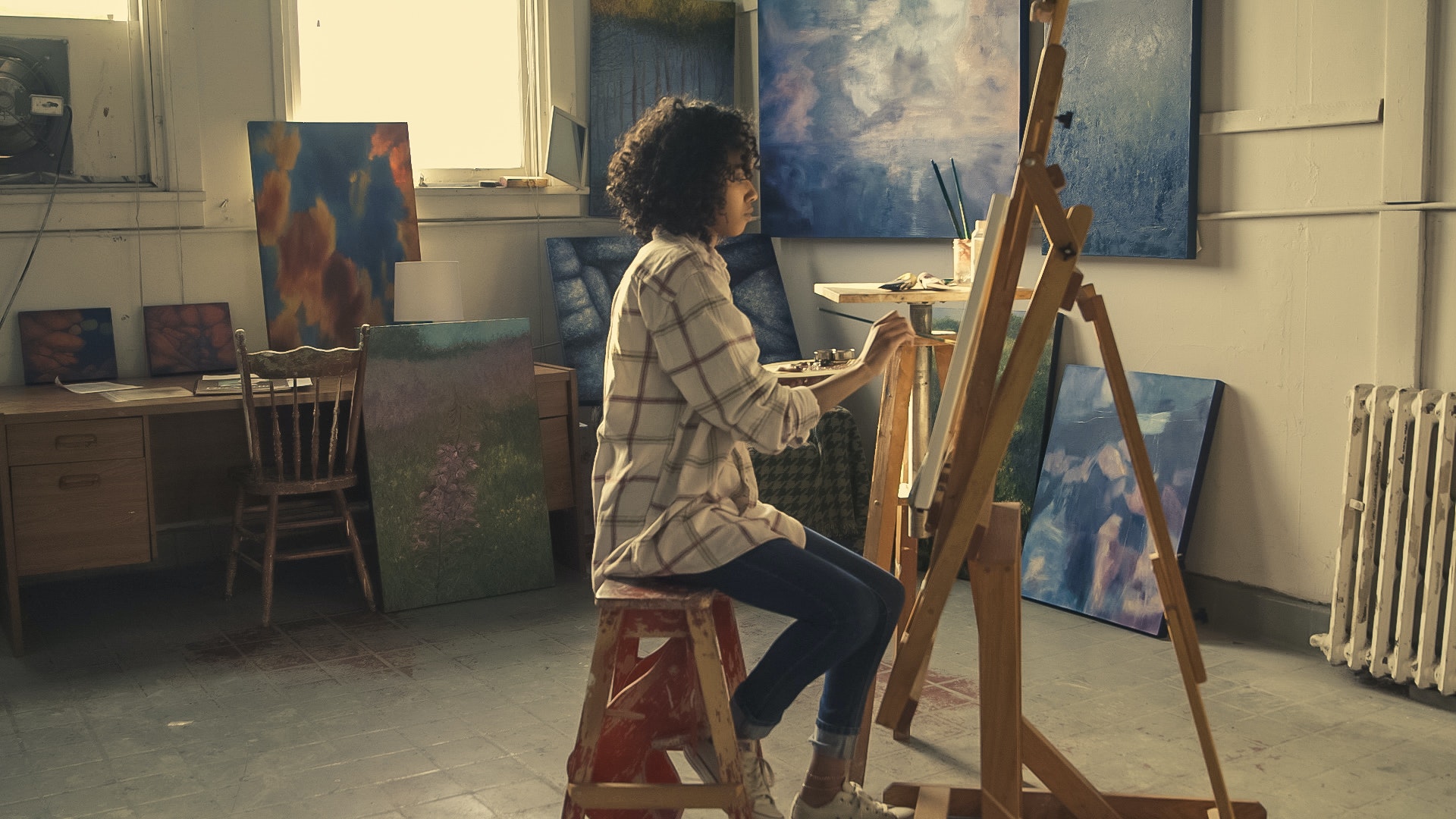 Une artiste peignant une toile dans son atelier.