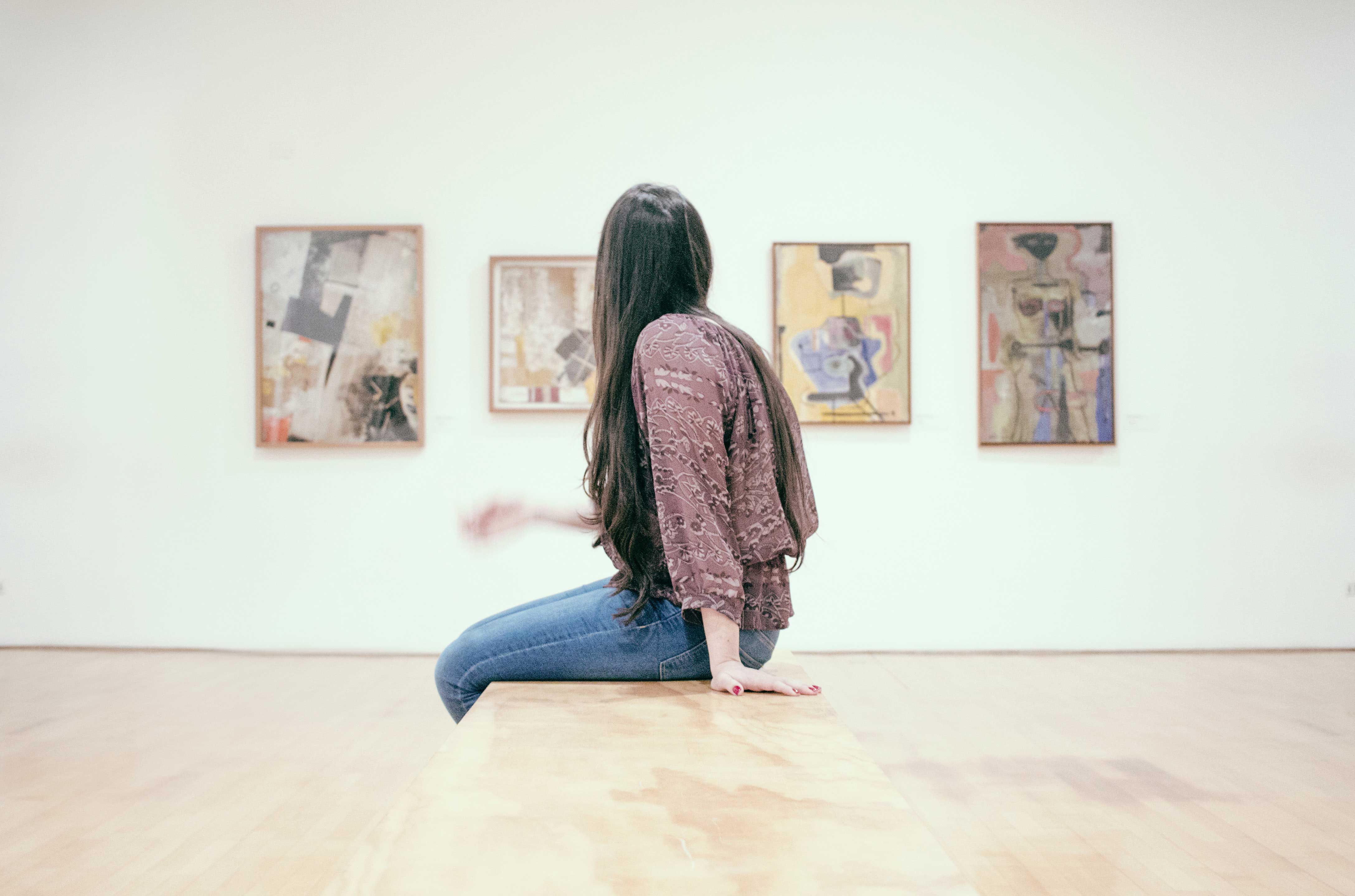Une amateur d’art observant des œuvres dans un lieu d’exposition